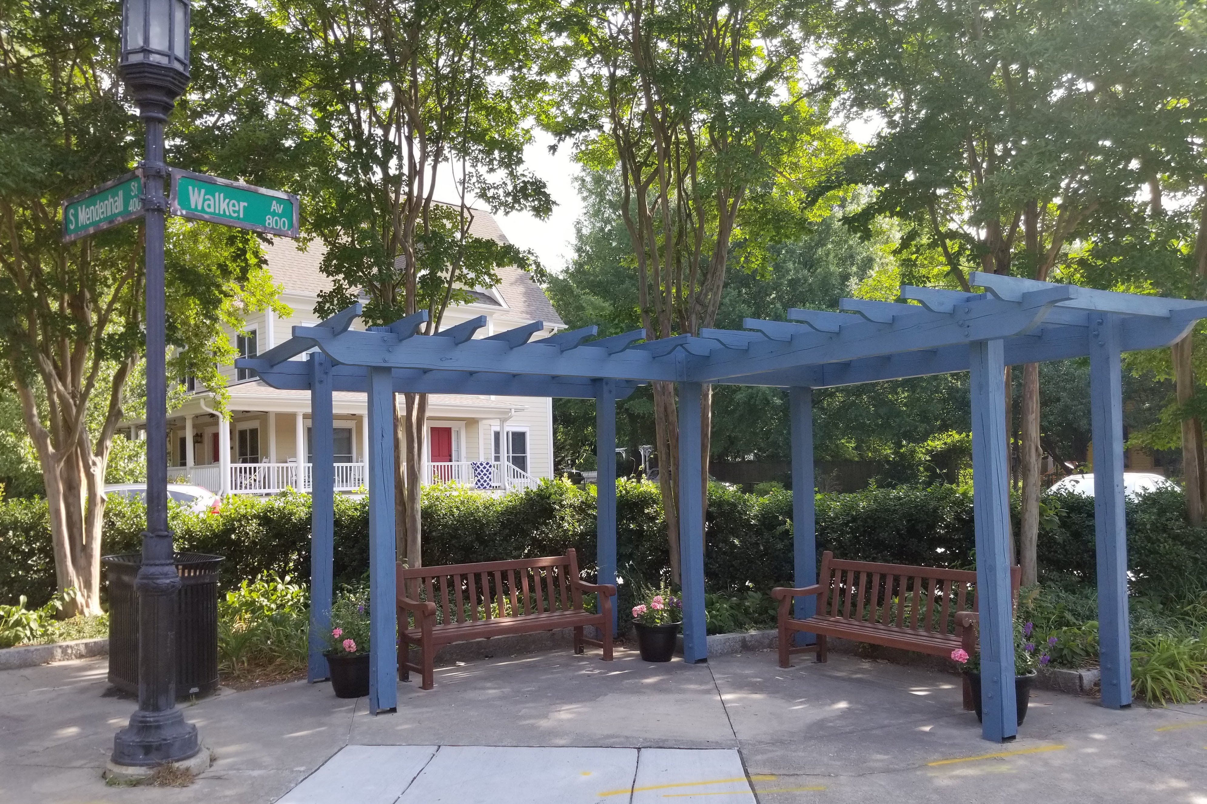 wooden pergola at corner with two wooden benches