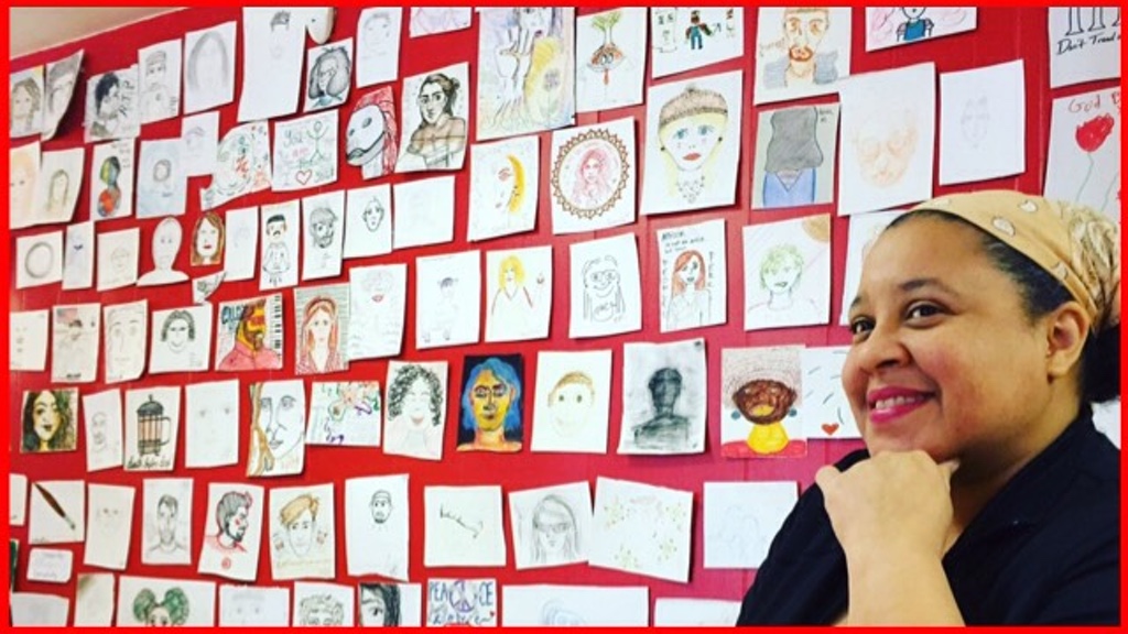 Karen and a wall with many small drawings of women