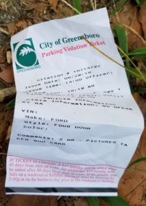 parking ticket crumpled up on the ground